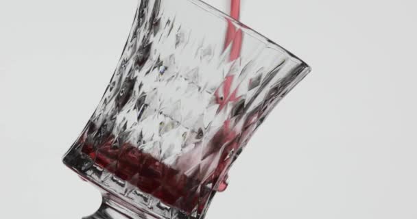 Růžové víno. Červené víno nalít do skleněného vína přes bílé pozadí — Stock video