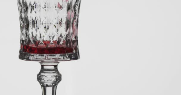 Rose wine. Red wine pour in wine glass over white background — Stock Video