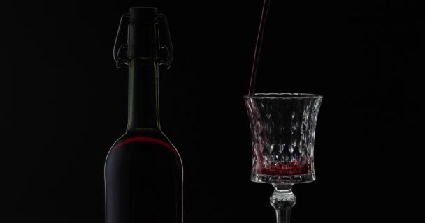 로즈 와인. 레드 와인 검은 배경 위에 와인 유리에 붓는다. 실루엣 — 비디오