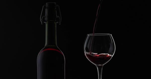 Vino rosa. Vino tinto vierta en copa de vino sobre fondo negro. Silueta — Vídeos de Stock