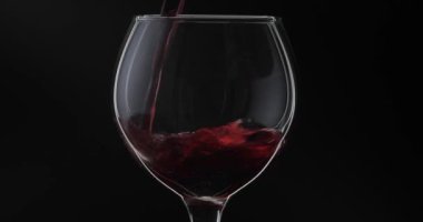 Gül şarabı. Kırmızı şarap siyah arka plan üzerinde şarap cam dökün. Siluet
