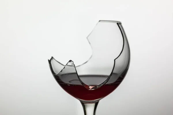 Beyaz arka planda kırmızı şarap ile Kırık şarap cam