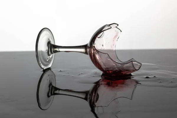 Isliç yüzeyde döşeme kırmızı şarap ile Kırık şarap bardağı