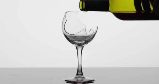 Vinho. Vinho tinto derramando em copo de vinho quebrado na superfície molhada — Vídeo de Stock
