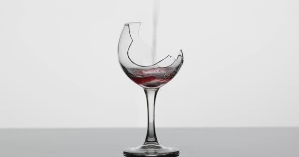 Wein. Rotwein in zerbrochenem Weinglas auf der nassen Oberfläche — Stockvideo