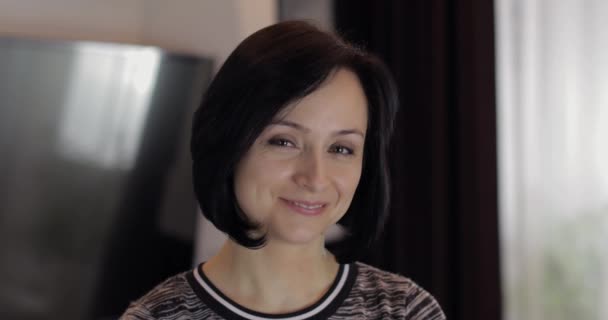 Retrato de la guapa caucásica joven morena sonriendo en casa — Vídeos de Stock