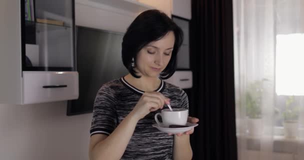 Retrato de una guapa joven morena sonriendo y bebiendo café de la taza — Vídeo de stock