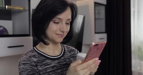 Женщина, общающаяся в социальных сетях с помощью смартфона, наслаждается общением с другом — стоковое видео
