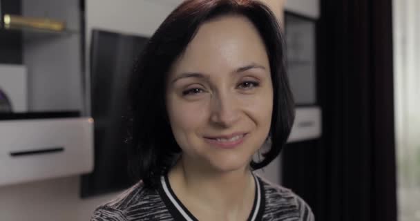 Portret van mooie Kaukasische jonge brunette vrouw glimlachend thuis — Stockvideo