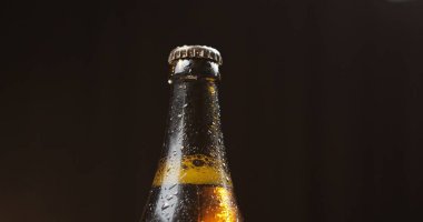 Siyah bir arka plan üzerinde soğuk bira şişesi. Kondens