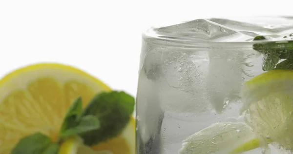 Kaca dengan minuman dingin dengan daun mint, kapur, lemon dan es batu — Stok Foto