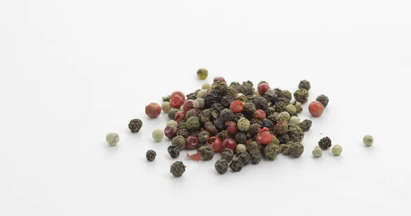 Mezcla de pimienta multicolor. Guisantes con especias. Macro sobre fondo blanco —  Fotos de Stock