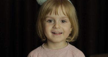 Küçük bir sarışın sevimli kız yüzünü kapat. Gülümseyen kız. İçeride. Portre vurdu