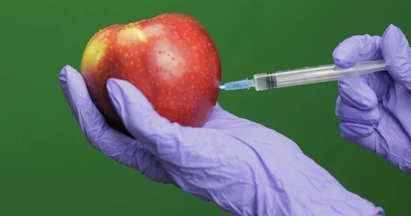 Científica hace una inyección con una jeringa de medicamento en manzana — Foto de Stock