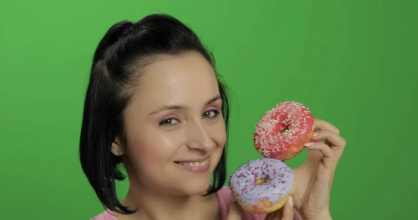 Happy beautiful young girl posing and having fun with donuts. Chroma key — Stock Photo, Image