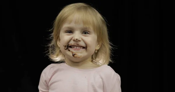 Děti jedí rozpuštěnou čokoládu a šlehačku. Špinavá tvář — Stock fotografie