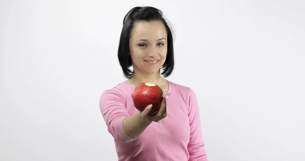 Ung vacker med rött äpple erbjuder bit till betraktaren. Hälsosam kost — Stockfoto