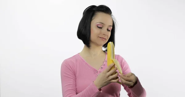 年轻美丽的女人剥下一个大香蕉 — 图库照片
