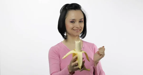 Giovane bella donna con una grande banana. Offerta morso allo spettatore — Foto Stock