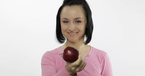 Ung vacker med rött äpple erbjuder bit till betraktaren. Hälsosam kost — Stockfoto