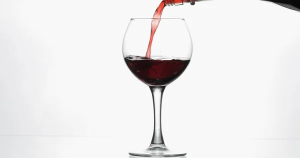 Vino rosato. Vino rosso versare in bicchiere di vino su sfondo bianco — Foto Stock