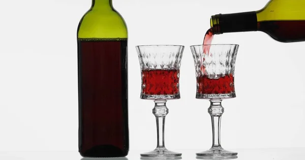 Vino rosato. Vino rosso versare in bicchiere di vino su sfondo bianco — Foto Stock