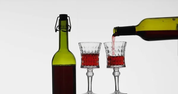 Ροζέ κρασί. Κόκκινο κρασί χύνουμε σε γυαλί κρασιού σε λευκό φόντο — Φωτογραφία Αρχείου