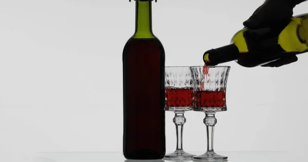 Vino rosato. Vino rosso versare in bicchiere di vino su sfondo bianco — Foto Stock