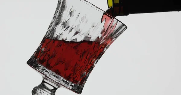 Rose wijn. Rode wijn pour in wijn glas over witte achtergrond — Stockfoto