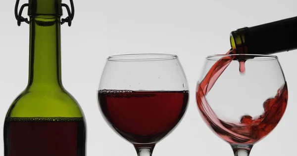 Ροζέ κρασί. Κόκκινο κρασί χύνουμε σε γυαλί κρασιού σε λευκό φόντο — Φωτογραφία Αρχείου