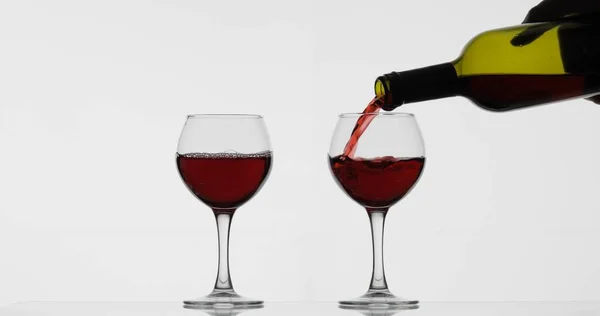 Vino rosato. Vino rosso versare in bicchiere di vino su sfondo bianco — Foto Stock