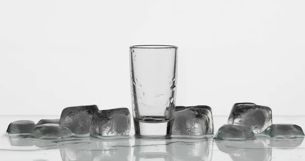 Порожня склянка горілки з кубиками льоду. Білий фон — стокове фото