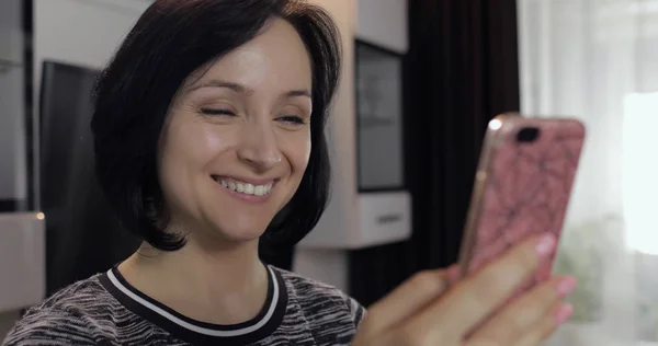 Woman having video chat using smartphone enjoying chatting to friend