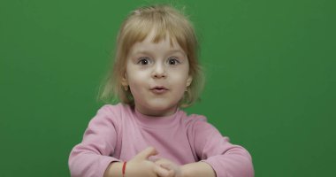 Mutlu üç yaşında çocuk. Sevimli kız surat yapıyor. Renk Anahtarı