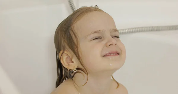 Atractiva niña de tres años toma un baño. Limpieza y lavado del cabello —  Fotos de Stock