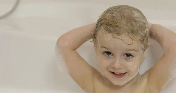 Ελκυστικό κορίτσι τριών ετών παίρνει ένα λουτρό. Καθαρισμός και πλύσιμο των μαλλιών — Φωτογραφία Αρχείου