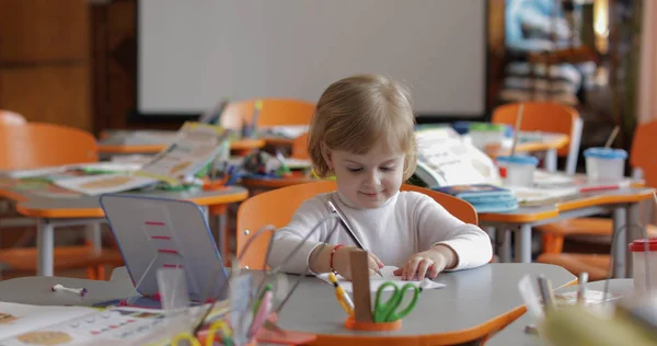 教室のテーブルで絵を描く少女。教育。机に座っている子供 — ストック写真