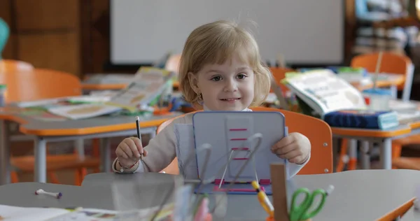 Meisje tekening aan de tafel in de klas. Onderwijs. Kinderzitje bij een bureau — Stockfoto