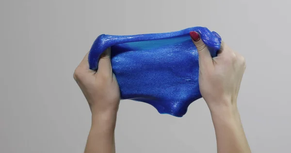 Női kéz játszik furcsán kielégítő kék nyálkás ragacsos anyag. Antistressz — Stock Fotó