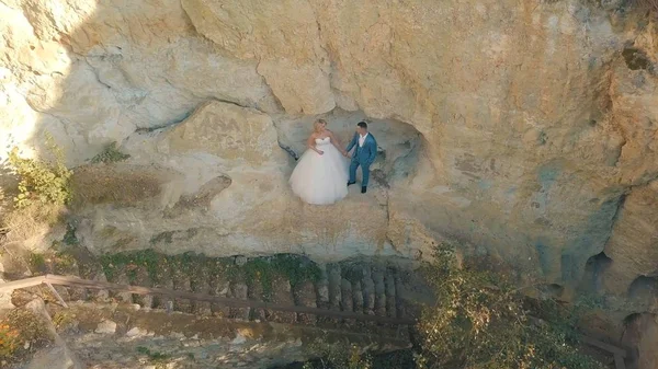 Pareja de boda de pie en una pendiente de la colina de la montaña. Precioso novio y novia —  Fotos de Stock