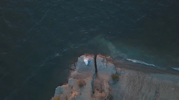 Pareja de boda en una pendiente de la colina de la montaña cerca del mar. Disparo aéreo — Foto de Stock