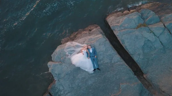 Pareja de boda en una pendiente de la colina de la montaña cerca del mar. Disparo aéreo —  Fotos de Stock