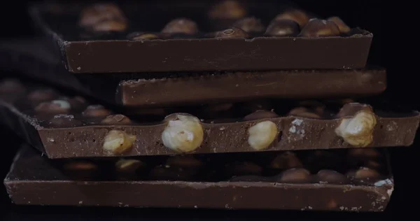 Bloques de chocolate negro con detalles de frutos secos macro de primer plano lento. Barras de chocolate — Foto de Stock