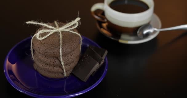 Smakelijk uitziende chocolade koekjes op een blauwe plaat op een donker oppervlak — Stockvideo