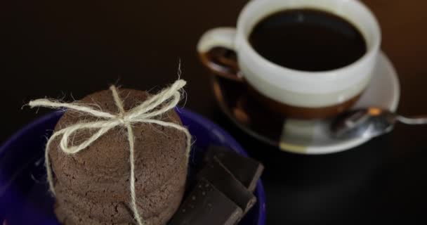 Galleta de chocolate de aspecto sabroso en un plato azul en la superficie oscura — Vídeos de Stock