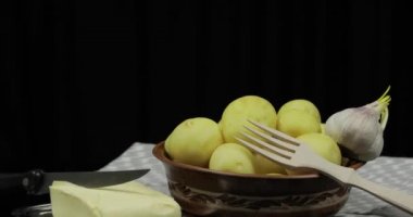 Yıkanmış taze patates pişirmeye hazır masada. Tereyağı, sarımsak, ahşap çatal