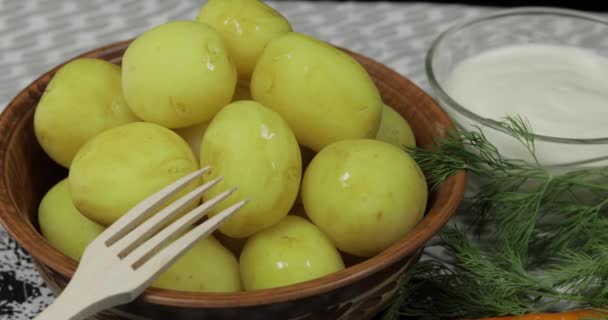 Lägga smör till kokt ny läcker potatis på plattan på bordet — Stockvideo