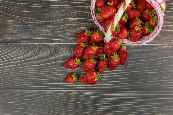 Fresas en una pequeña canasta sobre la mesa de madera. Lugar para su logotipo o texto — Foto de Stock