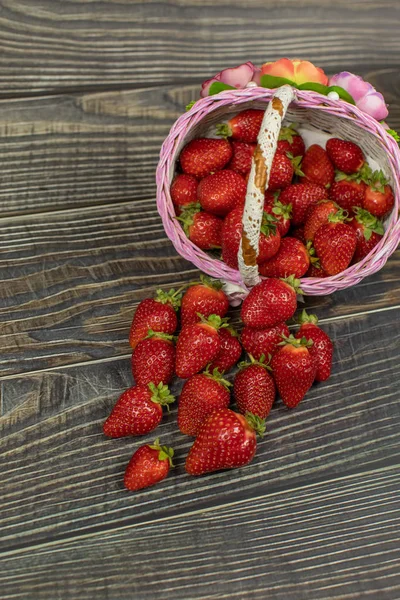 Fresas en una pequeña canasta sobre la mesa de madera. Lugar para su logotipo o texto — Foto de Stock