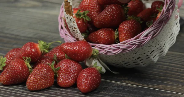 Strawberries in a small basket on the wooden table. Fresh red organic berries — Stock Photo, Image